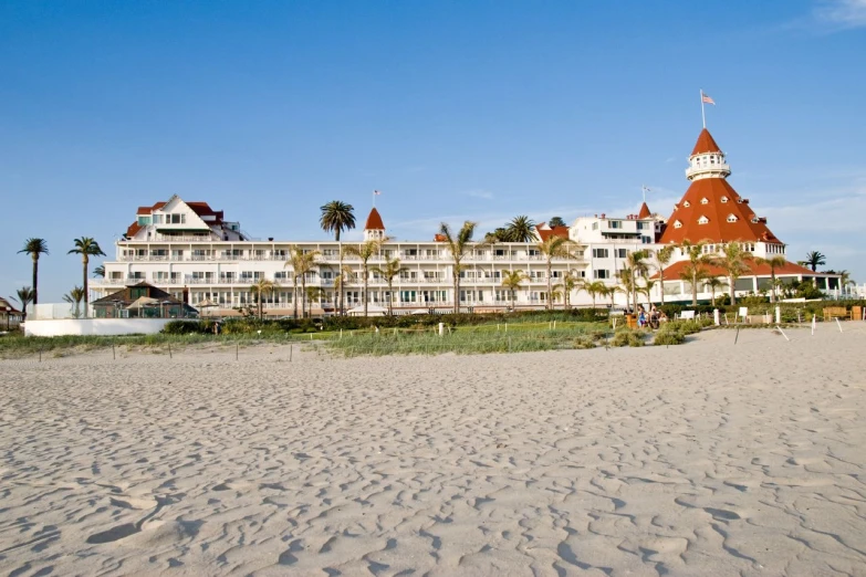 a beach and el building with palm trees on the shore