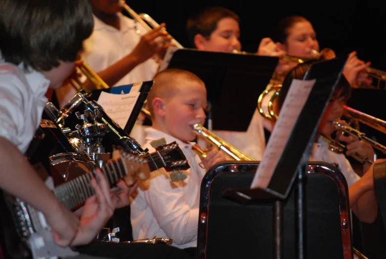 some children playing music in front of a group