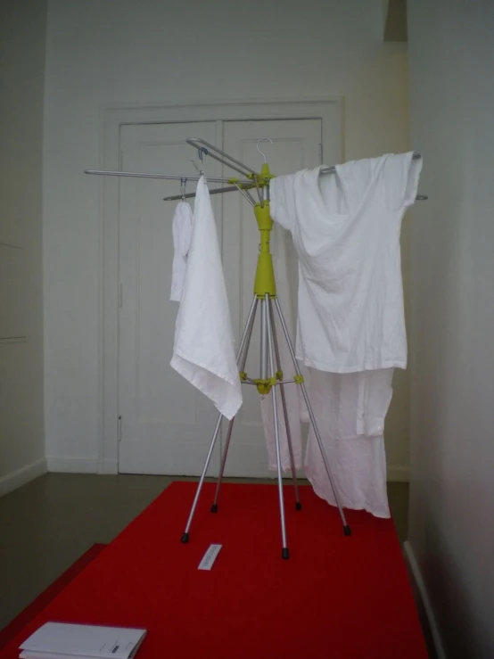 clothes on a rack on top of a red rug