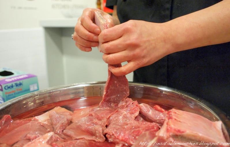 hands are sprinkling ham in a bowl