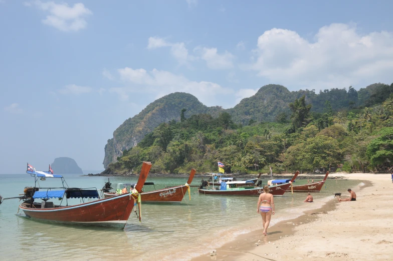 a beach with many small boats and people