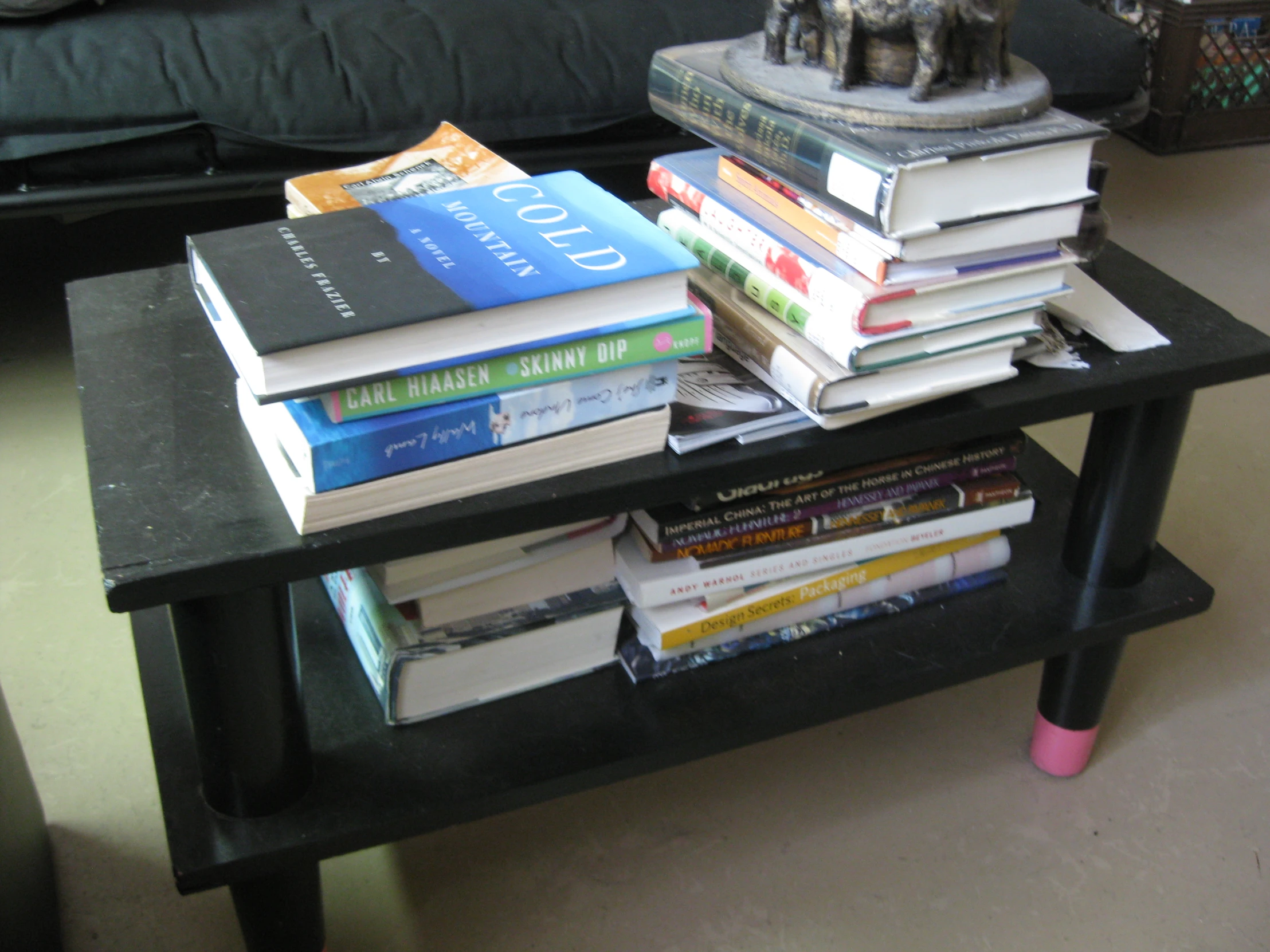 a coffee table filled with books and a little elephant figure