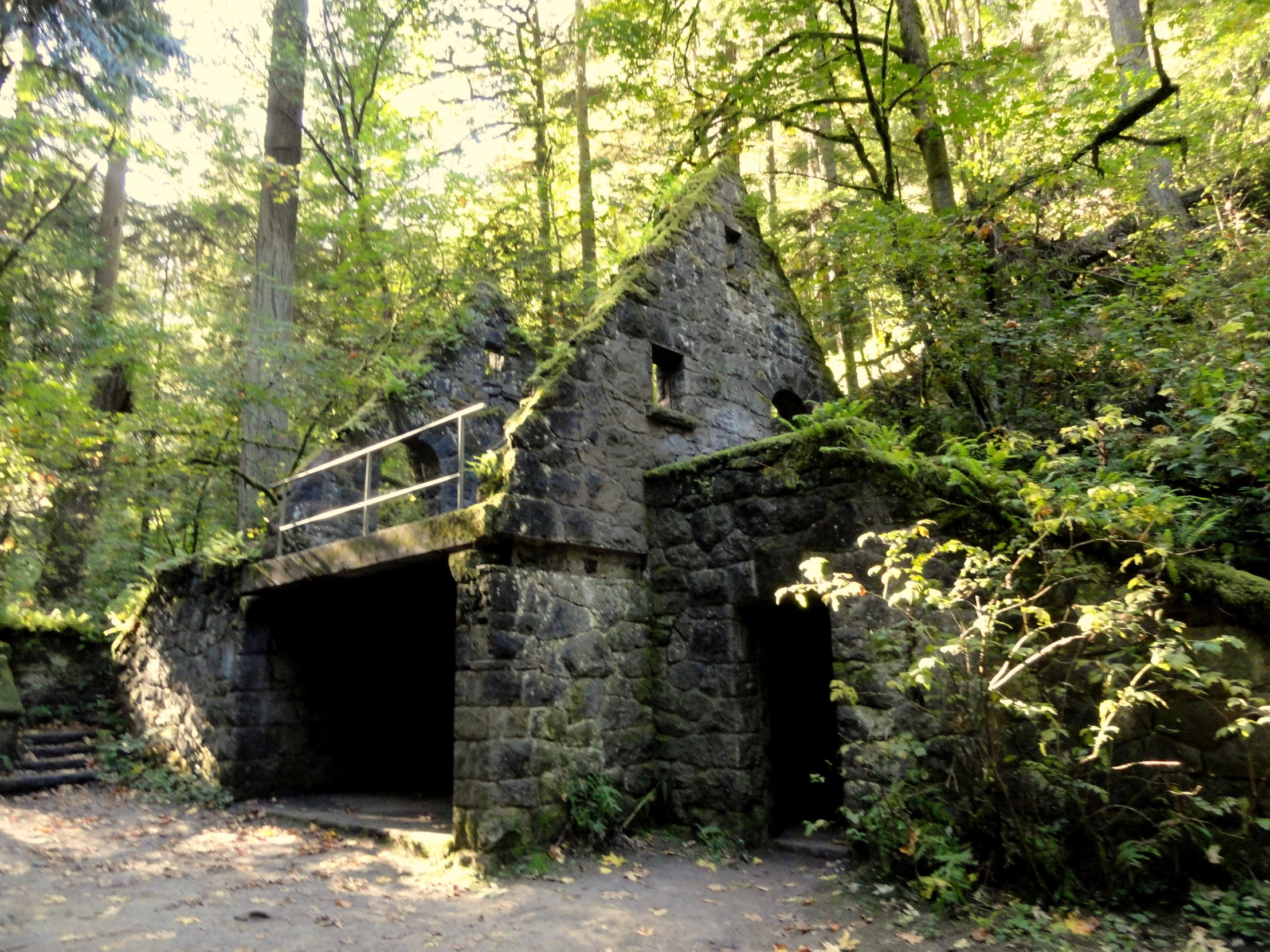 a small stone building in a forest