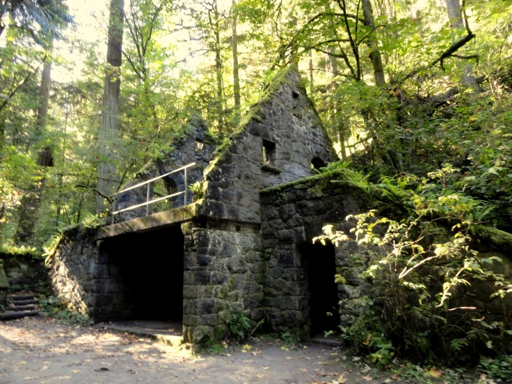 a small stone building in a forest