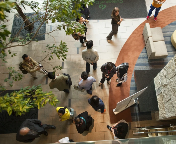 people walking through a lobby while two are in different directions