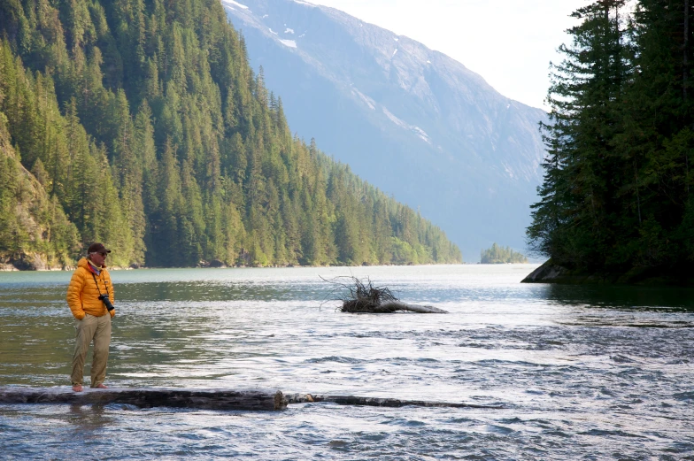 there is a man standing on the shore near a river