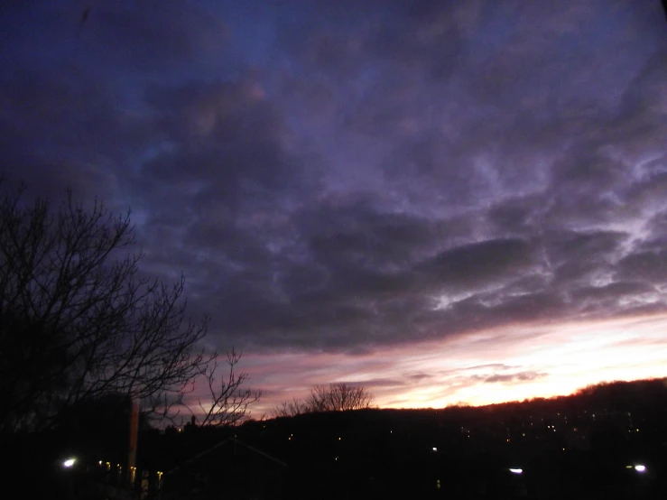 a dark and cloudy sky at night with lights on