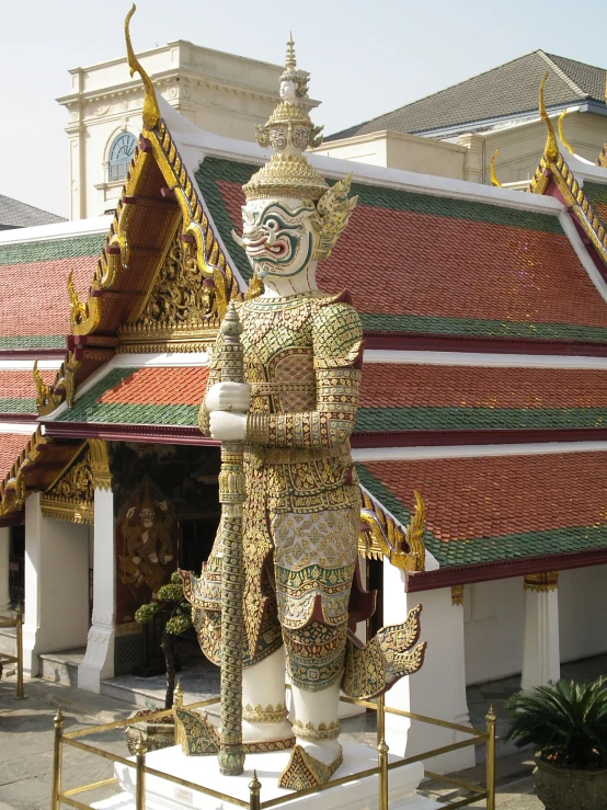 a statue in front of a temple has gold chains