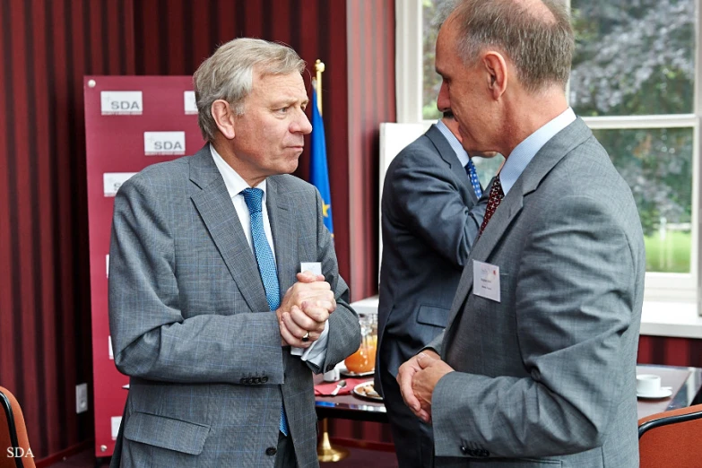 two men standing next to each other talking