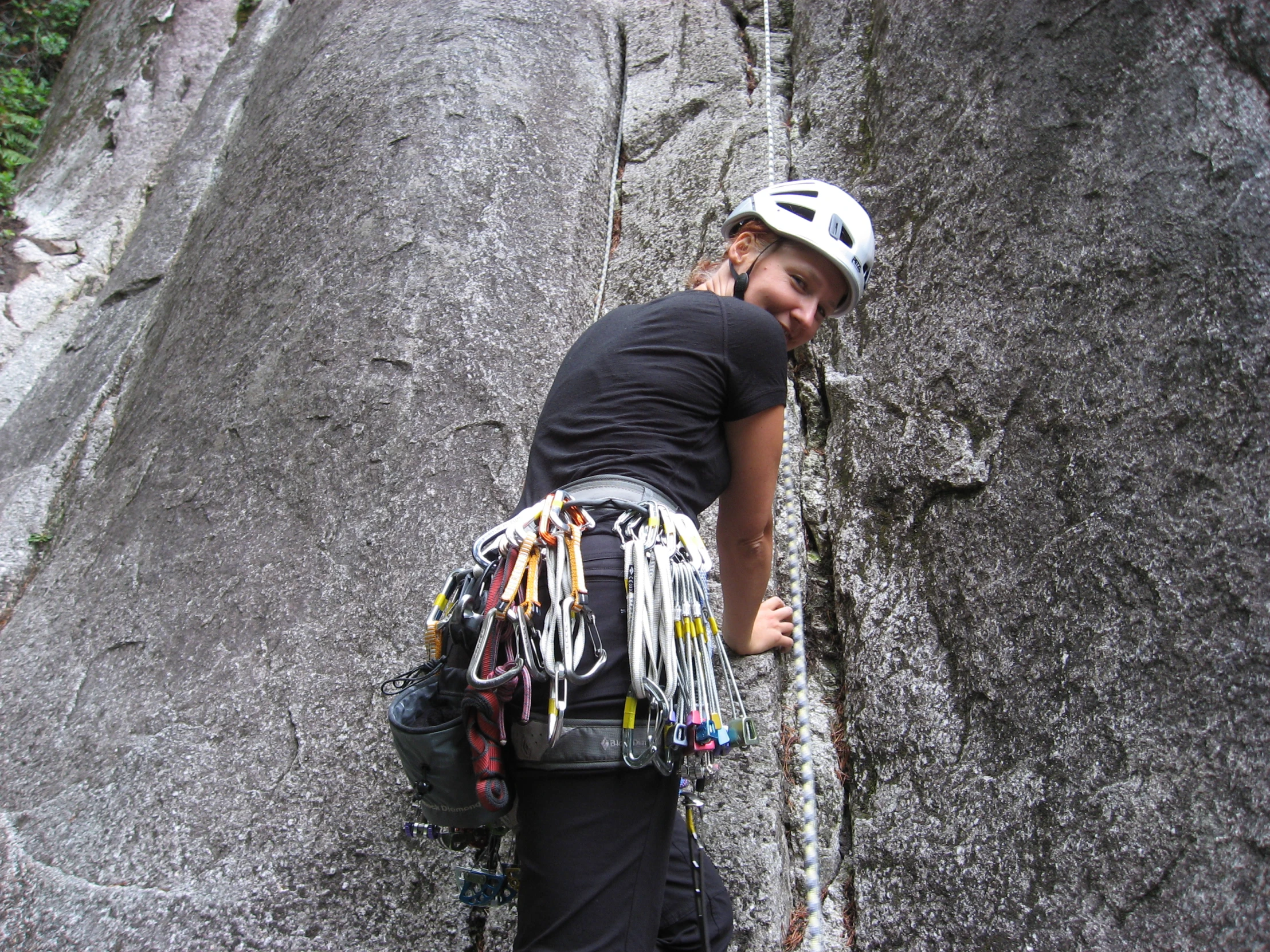 a man climbing up a steep cliff with lots of colorful beads