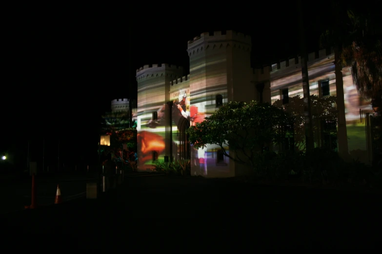 a lighted castle is lit up on the side of a building