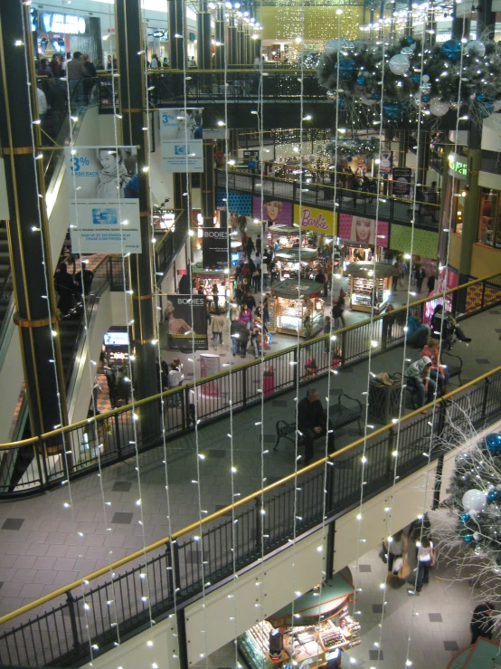 several people walking through a mall filled with items