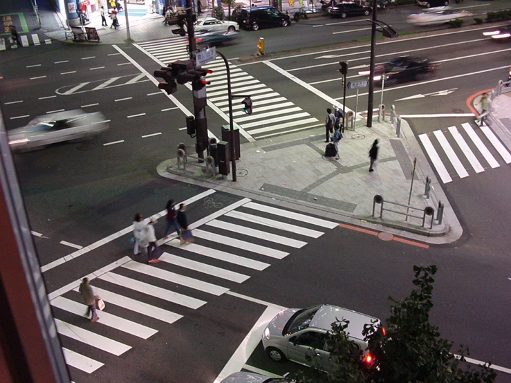 people are walking on the crosswalk at an intersection