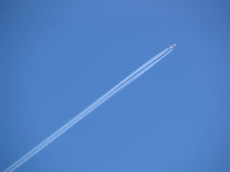 a white plane is flying through the sky