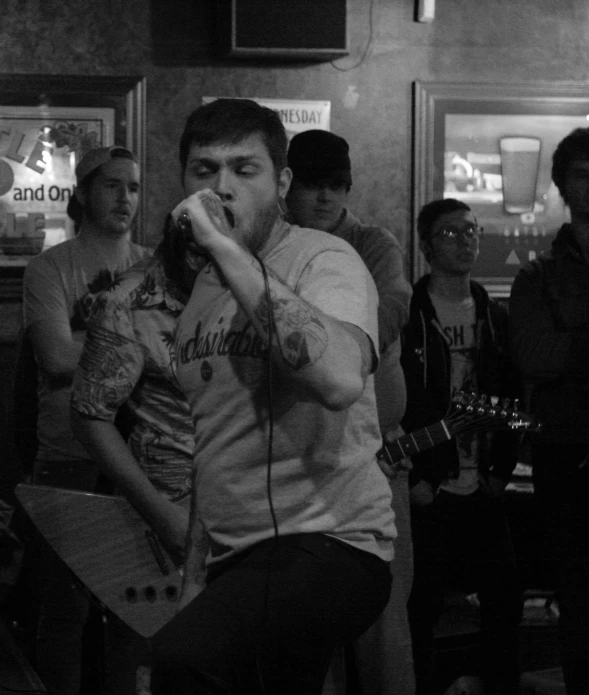 a black and white po of people with guitars and a man with long hair singing into a microphone