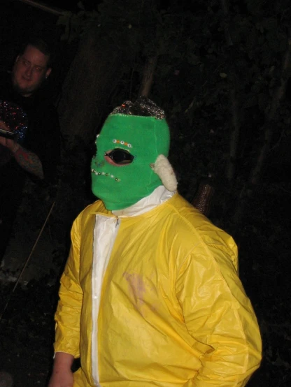 a man in a yellow suit with green and white mask