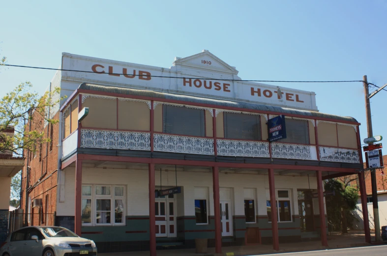 a old white building with red trim and balconies