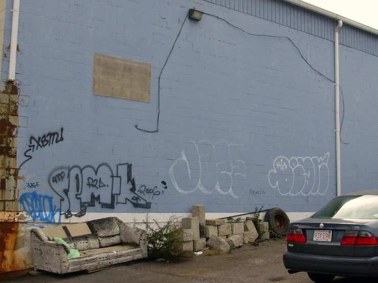 the back of a car in front of a large building with graffiti on it