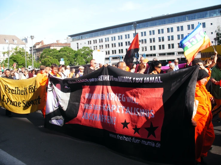 many people holding up colorful banners in a parade