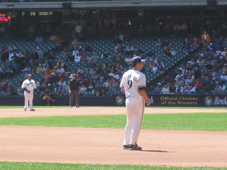 three men in baseball uniforms stand on the field