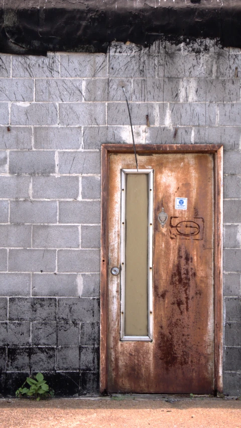 a metal door is in front of a gray brick wall