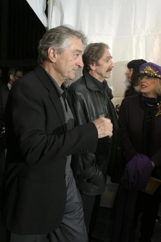 three men in coats and some people in hats