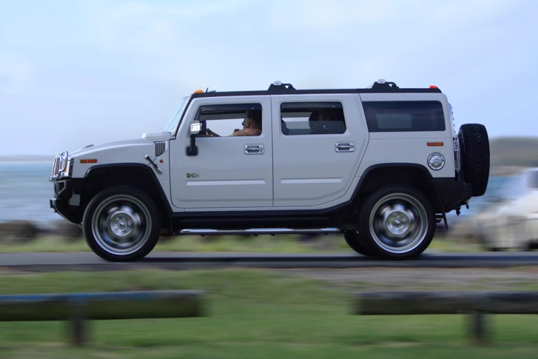 a white hummer parked near the shore