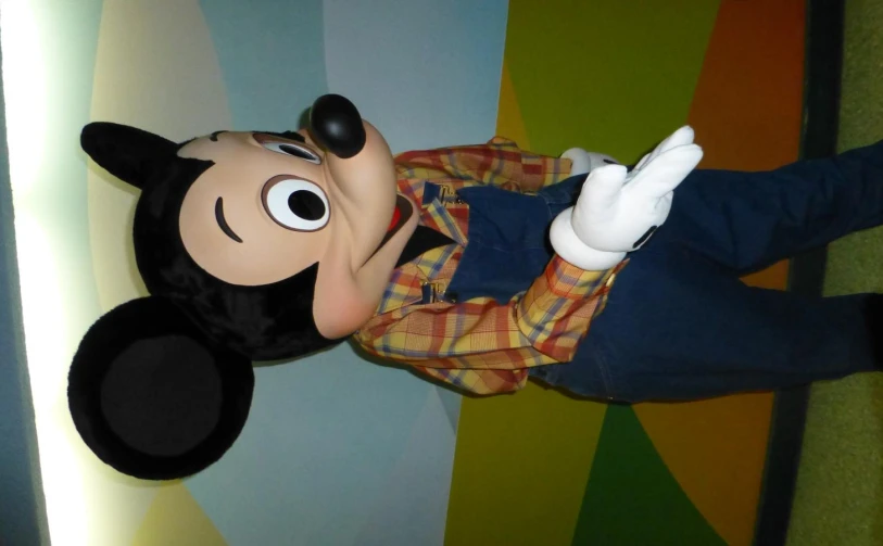 the mickey mouse mascot standing in front of a wall