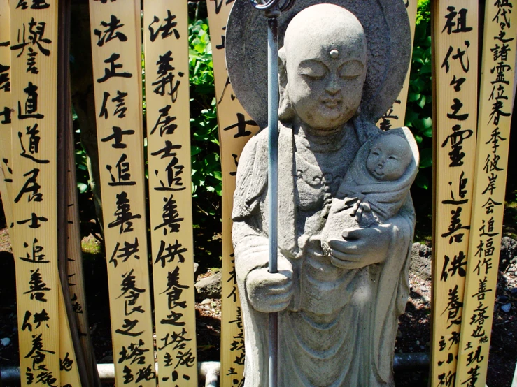 a statue with chinese writing on yellow pillars behind it
