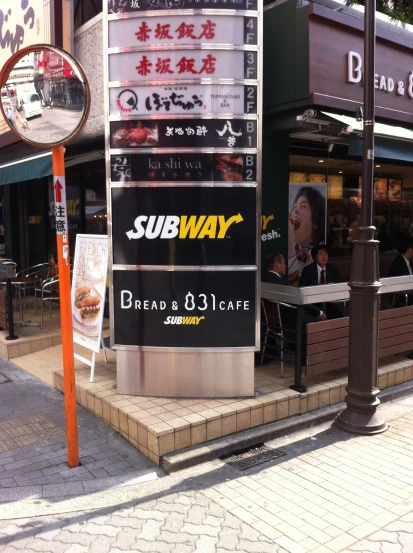 a sidewalk and sidewalk sign with advertising near sidewalk
