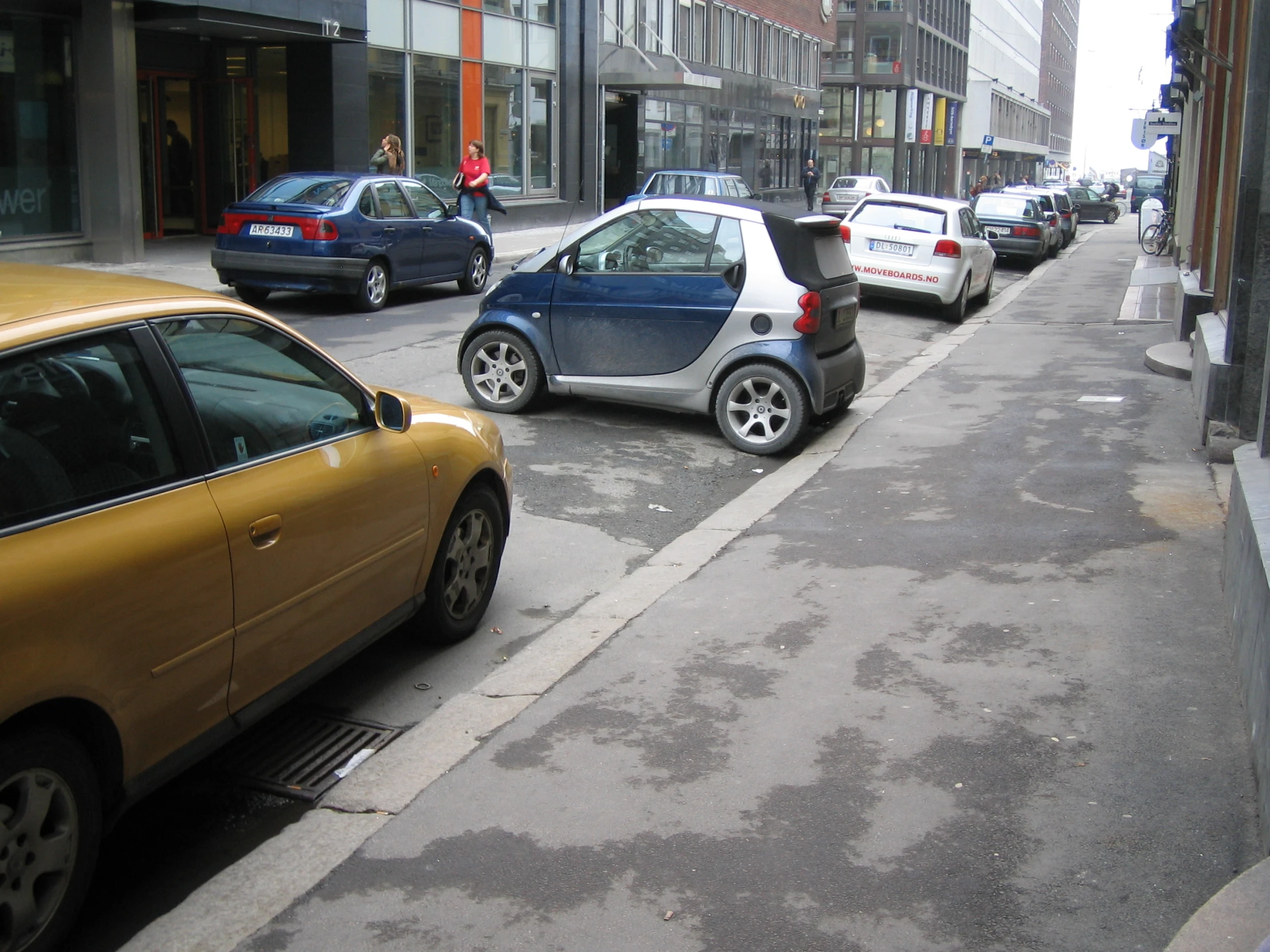 many cars on a street with buildings behind them