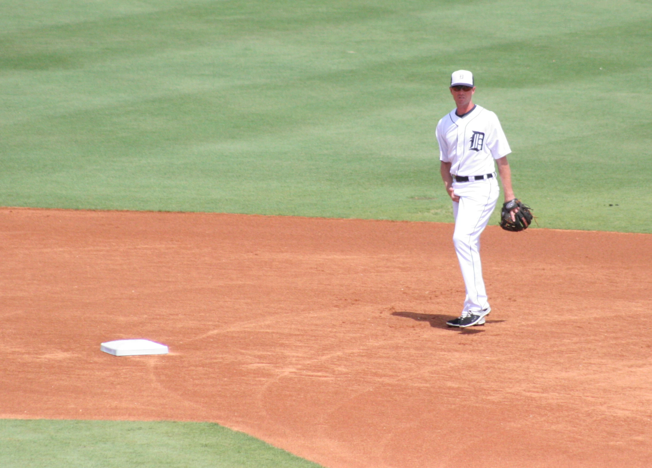 a man walking on a field with a catchers mitt