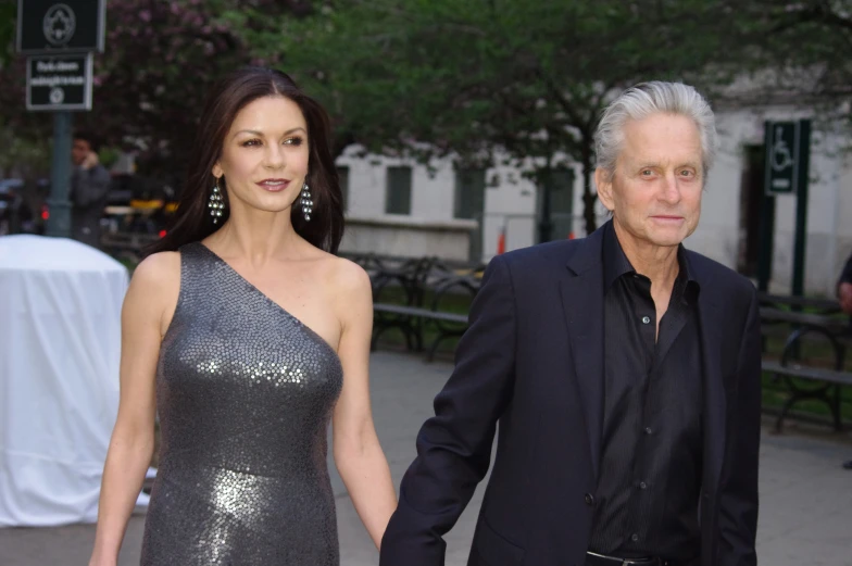 two women and a man holding hands at a formal event