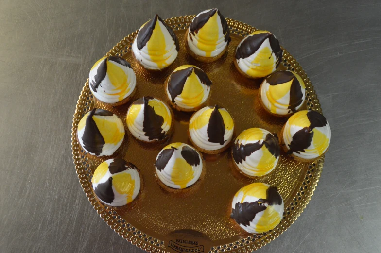 some cupcakes with chocolate and gold decoration sit on a tray