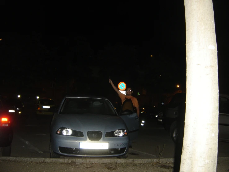 a car with a sticker on it parked in front of a traffic light