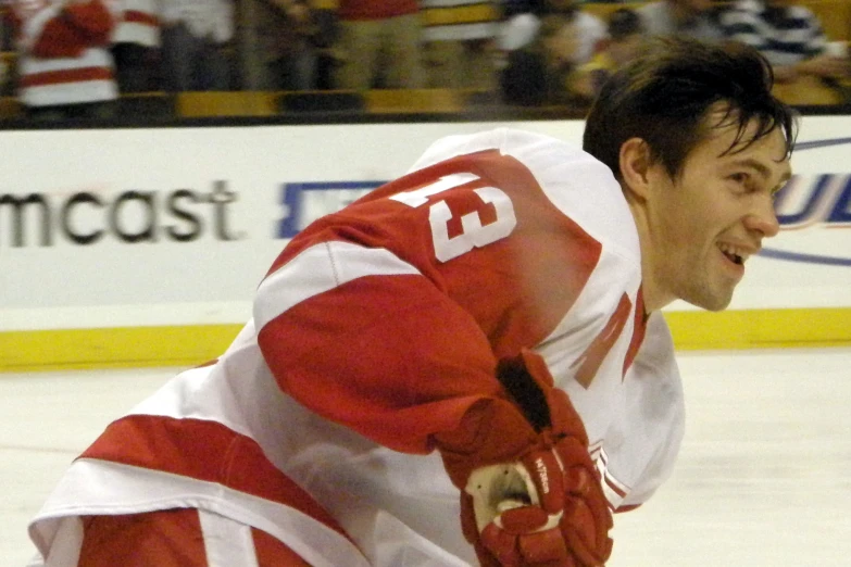 a man in a jersey and gloves standing on the ice