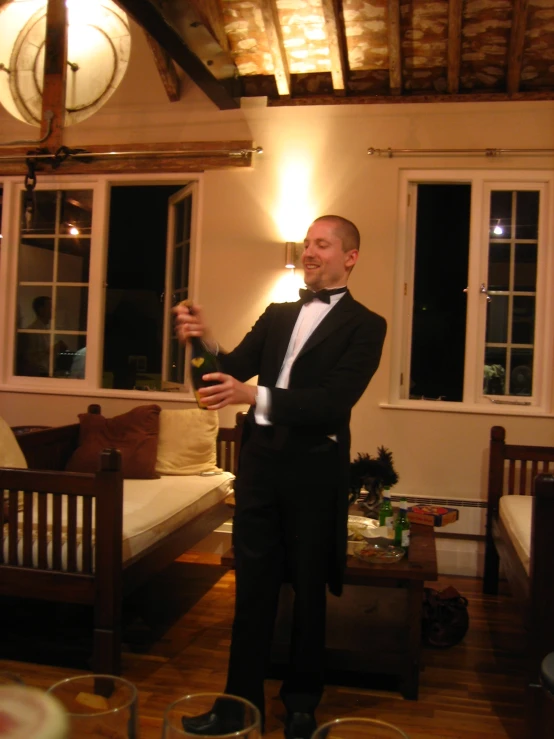 a man holding a bottle standing in a living room