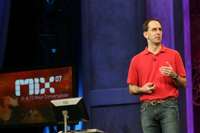 a man in red shirt giving a lecture