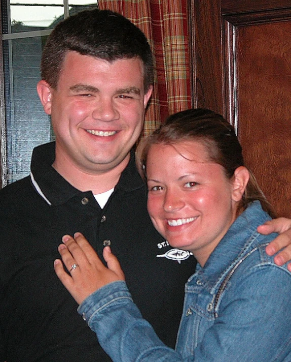 a young woman is hugging a man in the back