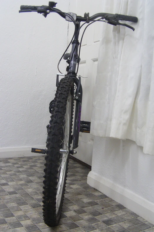 a bike resting on a tiled floor in the middle of a room