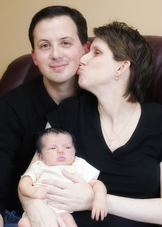 the man and woman are holding their baby