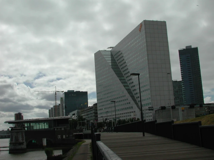 some tall buildings and water against a cloudy sky