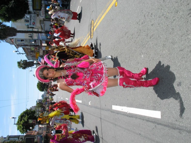 a woman in a pink dress is walking down the street