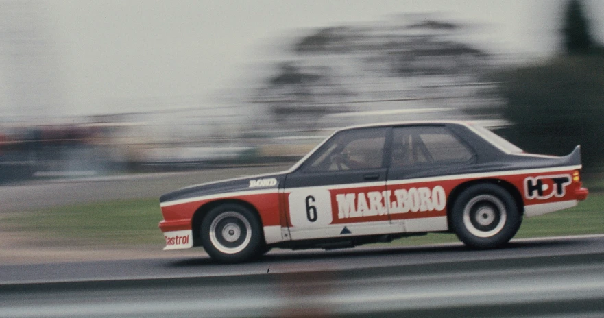 a man driving an old race car on a track