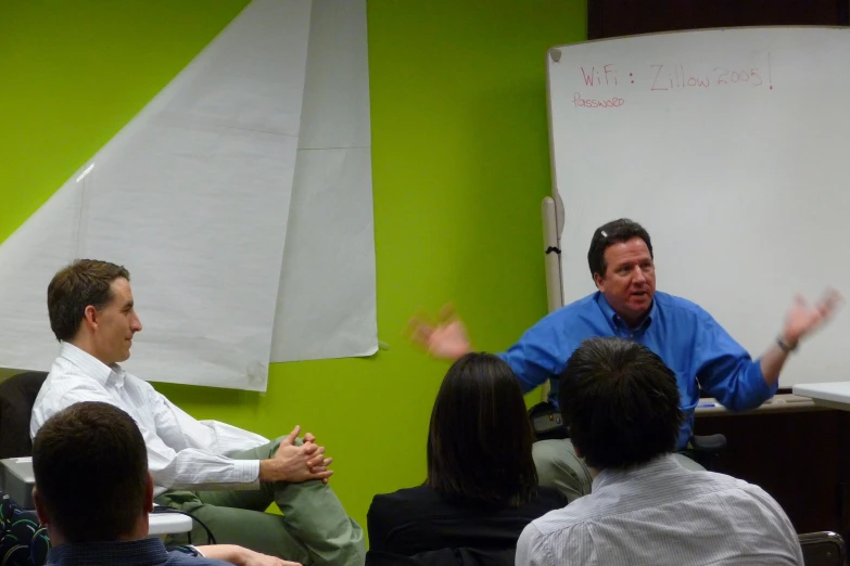 two men sitting at a table talking in a conference