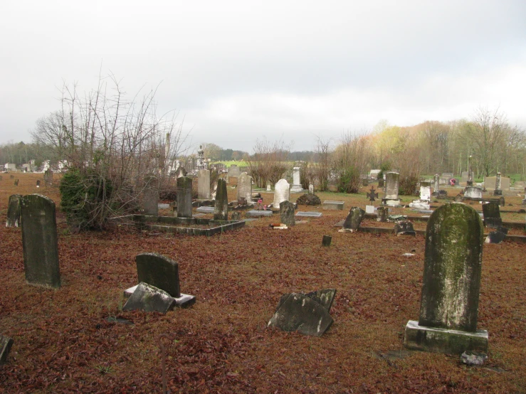 old and empty graves in a cemetery with red foliage