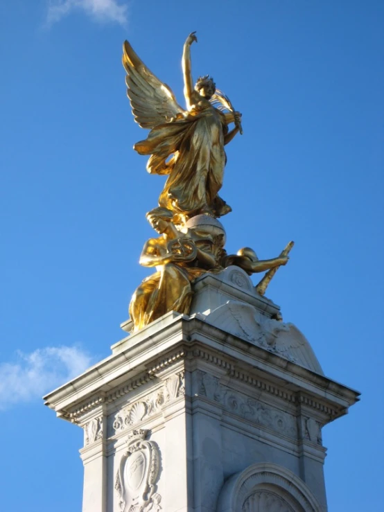 a gold and white statue atop a metal structure