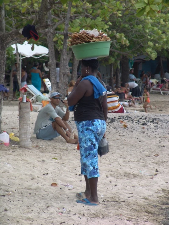 an african woman carrying many things on her head