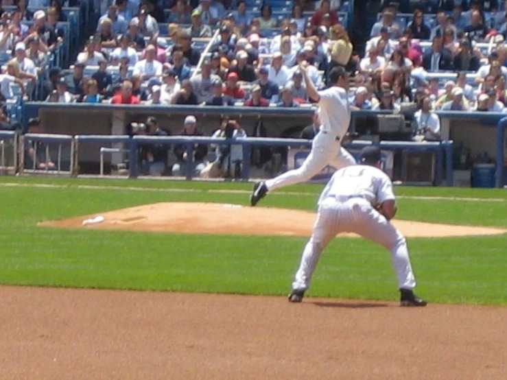 a baseball player throwing a ball to a catcher