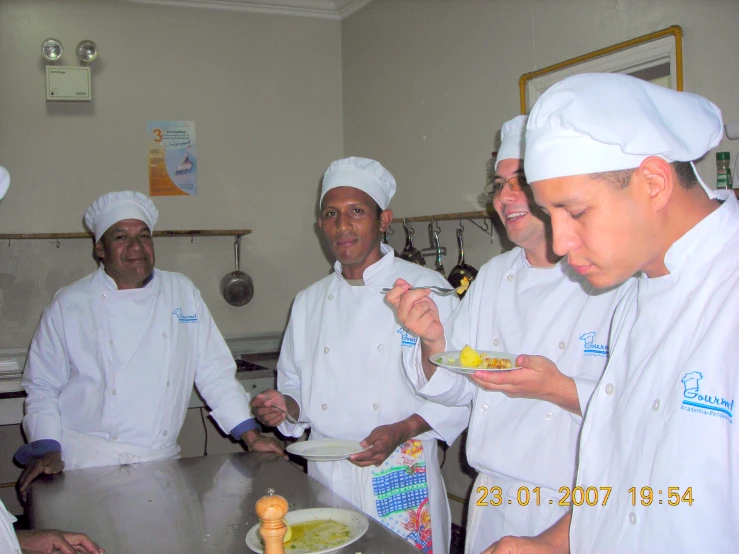 five chef eating food on the kitchen counter